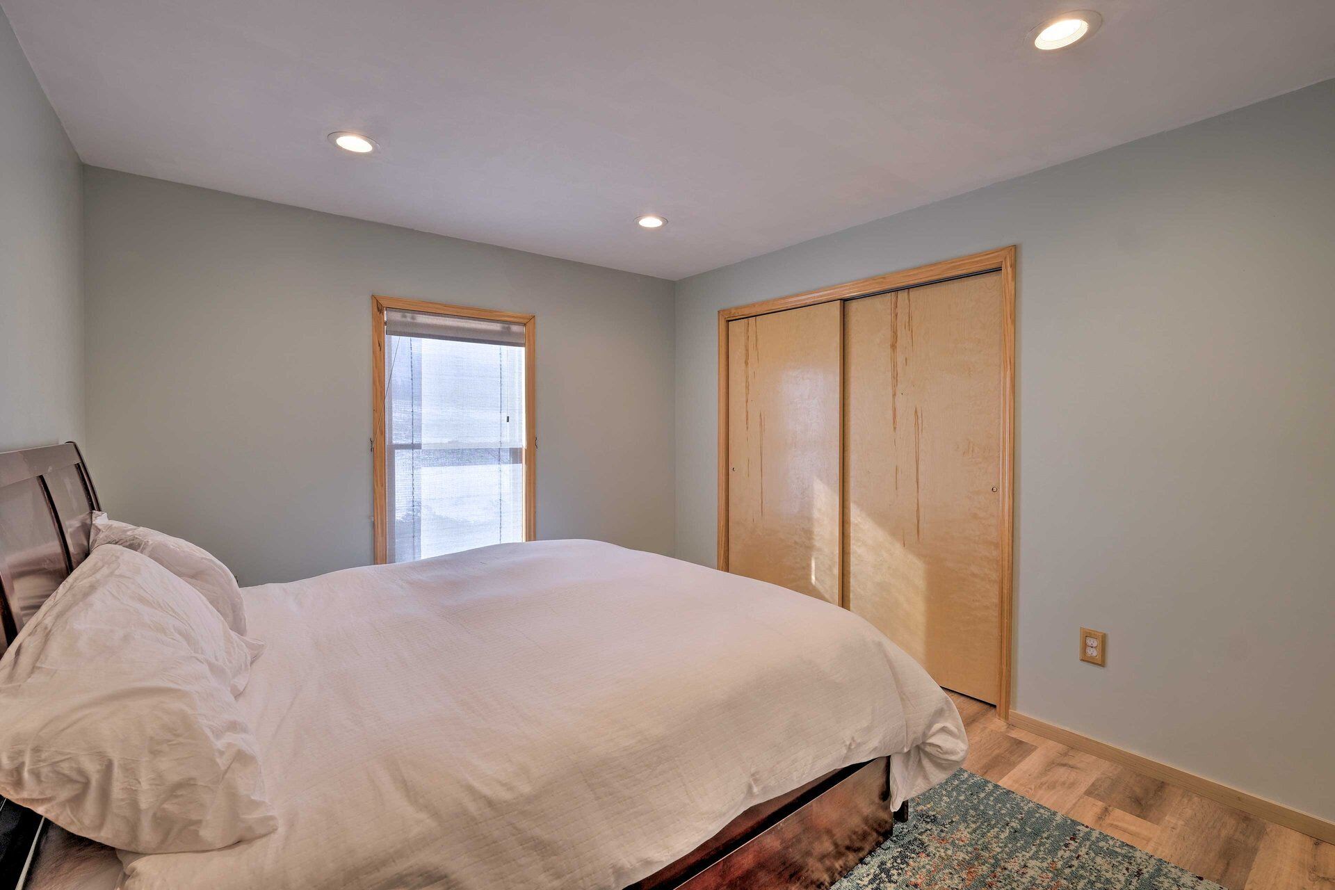 Une chambre à coucher avec un lit, une fenêtre et une armoire.