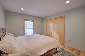 A bedroom with a bed, a window, and a wardrobe.