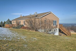 Une maison à deux étages, dotée d’une antenne parabolique, d’une terrasse et offrant une vue sur le paysage environnant.