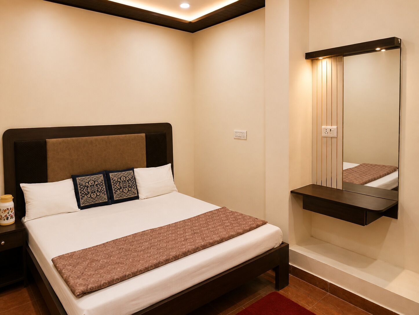 Une chambre à coucher comprenant un lit, une table de chevet, une commode et un miroir.