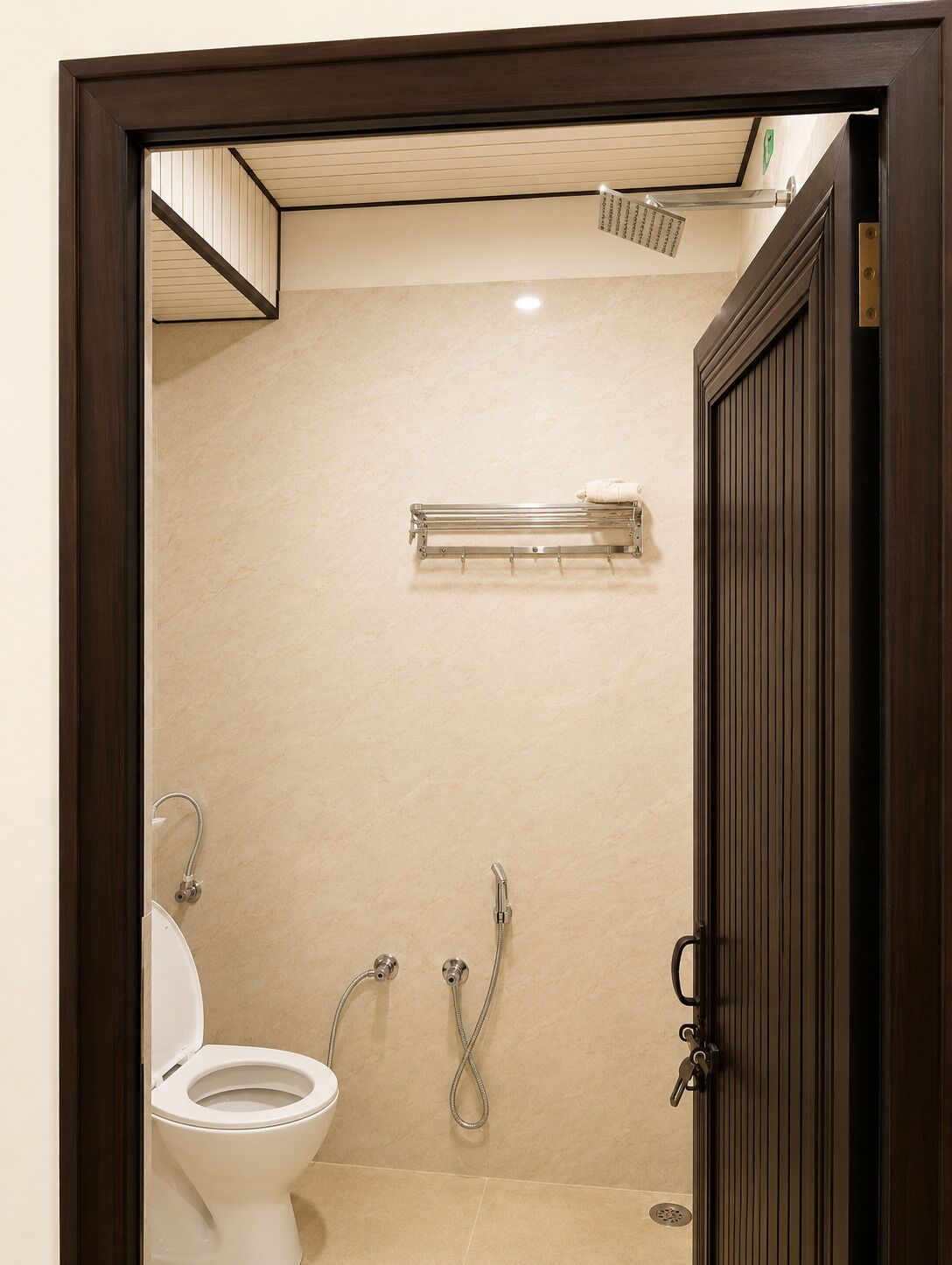 A bathroom with a toilet, a shower, and a towel rack.