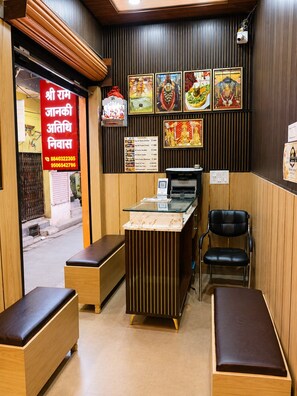 A restaurant interior with a counter, seating area, and wall decorations. - Shri Ram Janki Atithi Nivas (Varanasi)