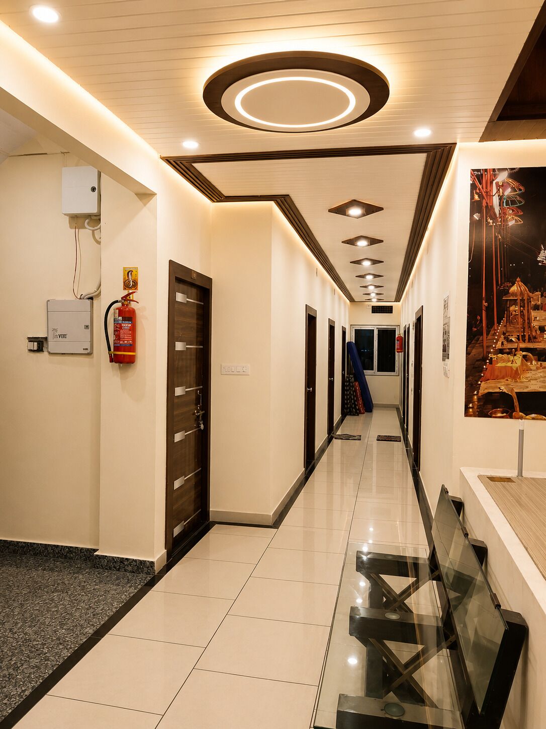 A hotel corridor with a fire extinguisher, a water heater, and a poster on the wall.