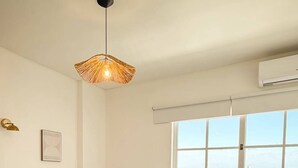 Una camera da letto con un letto, una finestra, un termosifone e una lampada a sospensione.