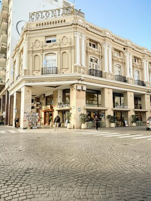 En historisk byggnad med utsmyckad arkitektur, ett kafé som heter ”Martinez” och en kullerstensgata.
