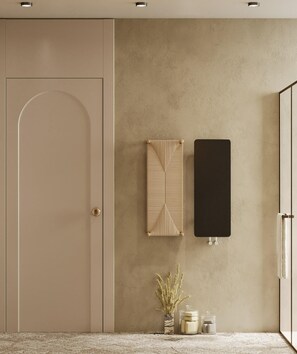 Un baño minimalista con una puerta color beige, una pared con textura, un perchero, un lavabo y un pequeño jarrón con plantas secas.