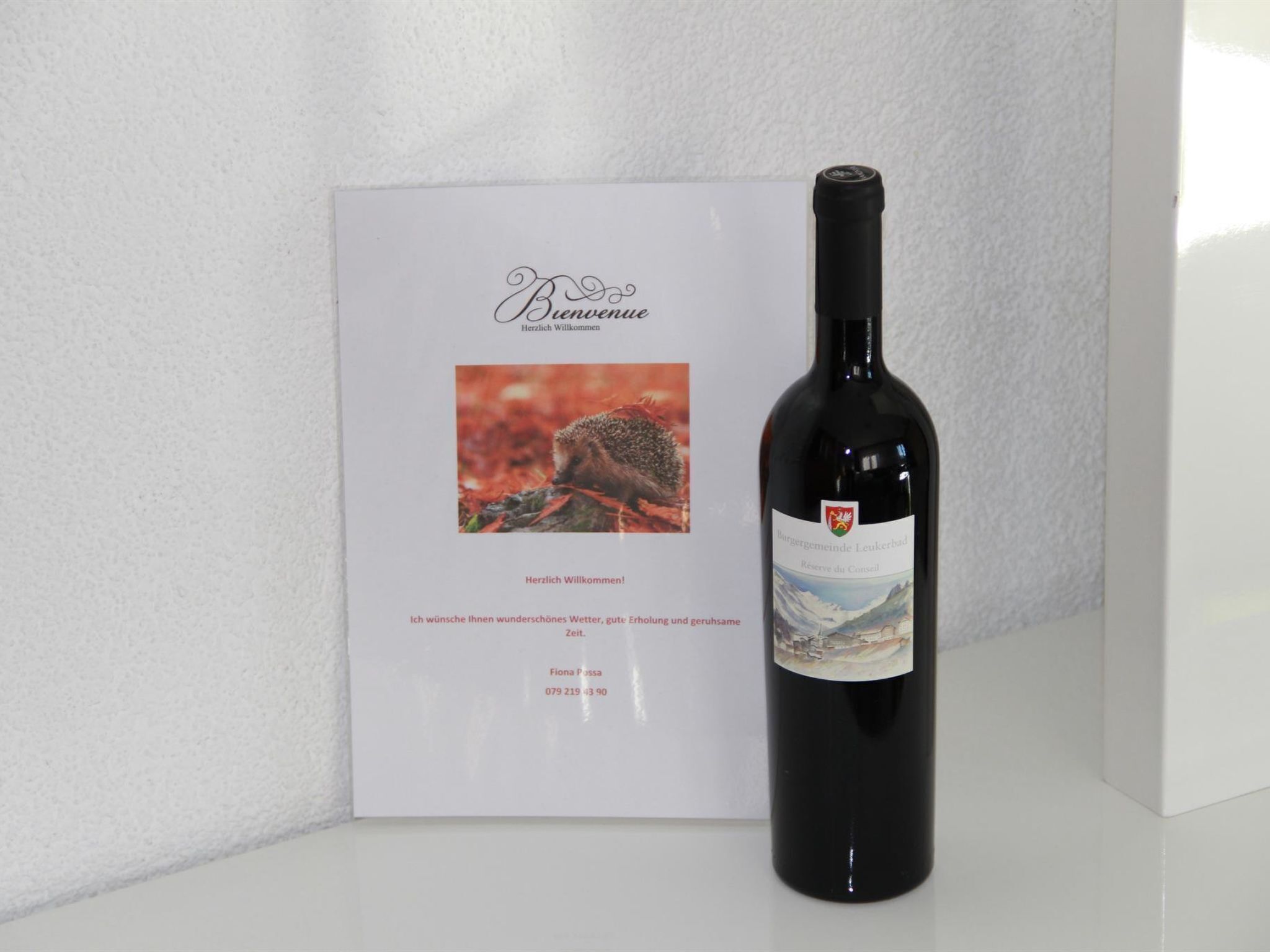 A bottle of wine with a label and a welcome card with a hedgehog image.