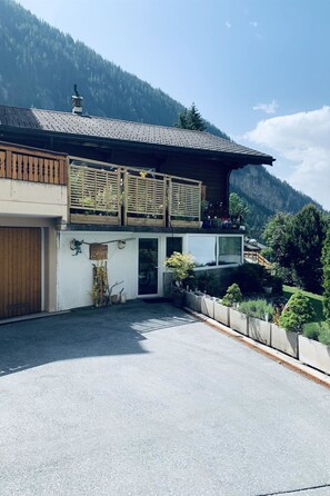 Ein Gebäude mit traditionellem Satteldach, Holzzaun und einem Schild mit der Aufschrift 'Chalet Solana'.