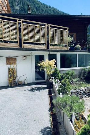 Ein zweistöckiges Gebäude mit Balkon, Holzzaun und einem Schild mit der Aufschrift 'Chalet Solana'.