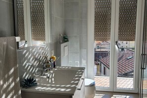 Een badkamer met een groot raam, een wastafel en een toilet.