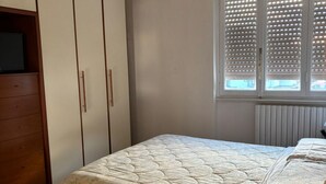 A bedroom with a bed, a dresser, and a window with blinds. - Your Lake Como getaway (Casa Amata) (Cernobbio)
