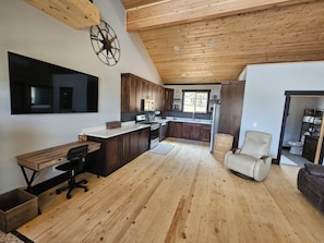 A modern kitchen with dark wooden cabinets, a large island, and a built-in oven. - Duck Creek Cabin near Brian Head, Zion and Bryce Canyon (Duck Creek Village)