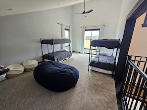 A dormitory room with bunk beds, a ceiling fan, and a large window. - Duck Creek Cabin near Brian Head, Zion and Bryce Canyon (Duck Creek Village)