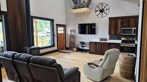 A modern living room with a leather sofa, a recliner, and a flat-screen TV. - Duck Creek Cabin near Brian Head, Zion and Bryce Canyon (Duck Creek Village)