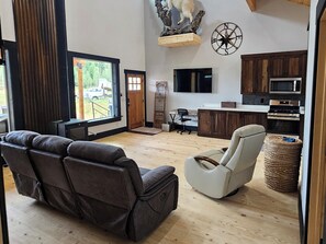 A modern living room with a leather sofa, a recliner, and a flat-screen TV. - Duck Creek Cabin near Brian Head, Zion and Bryce Canyon (Duck Creek Village)
