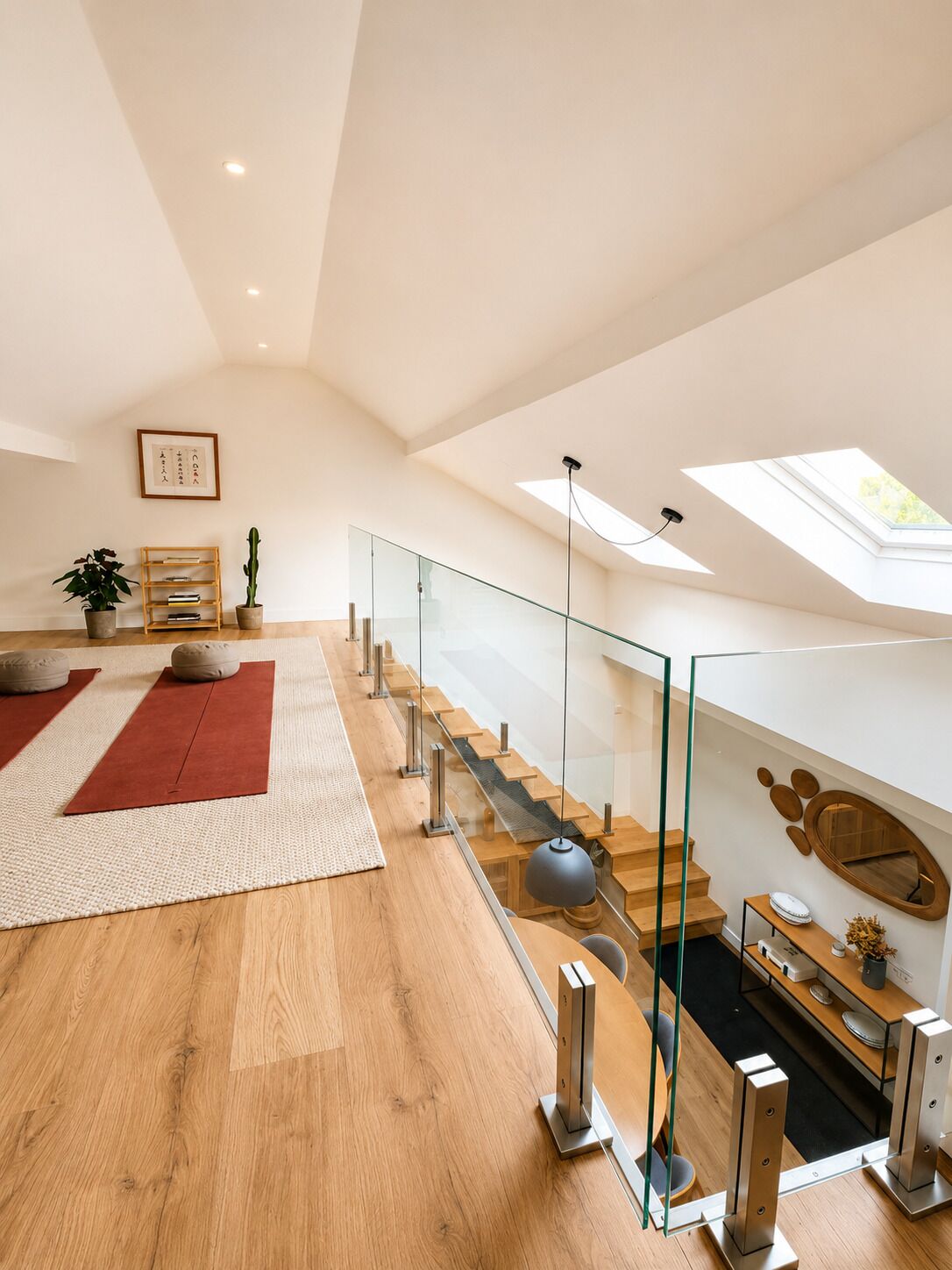 Un loft spacieux avec de hauts plafonds, un escalier en verre et une verrière.