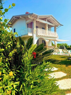 A two-story house with a balcony and a covered patio area. - Villa with pool and jacuzzi on the Garda Lake (Manerba del Garda)