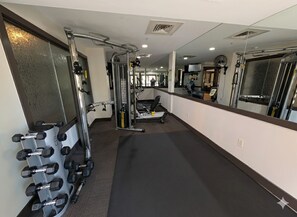 A gym with weight machines, a treadmill, and a mirror wall. - New Listing | King Bed | Steps from the slopes (Keystone)