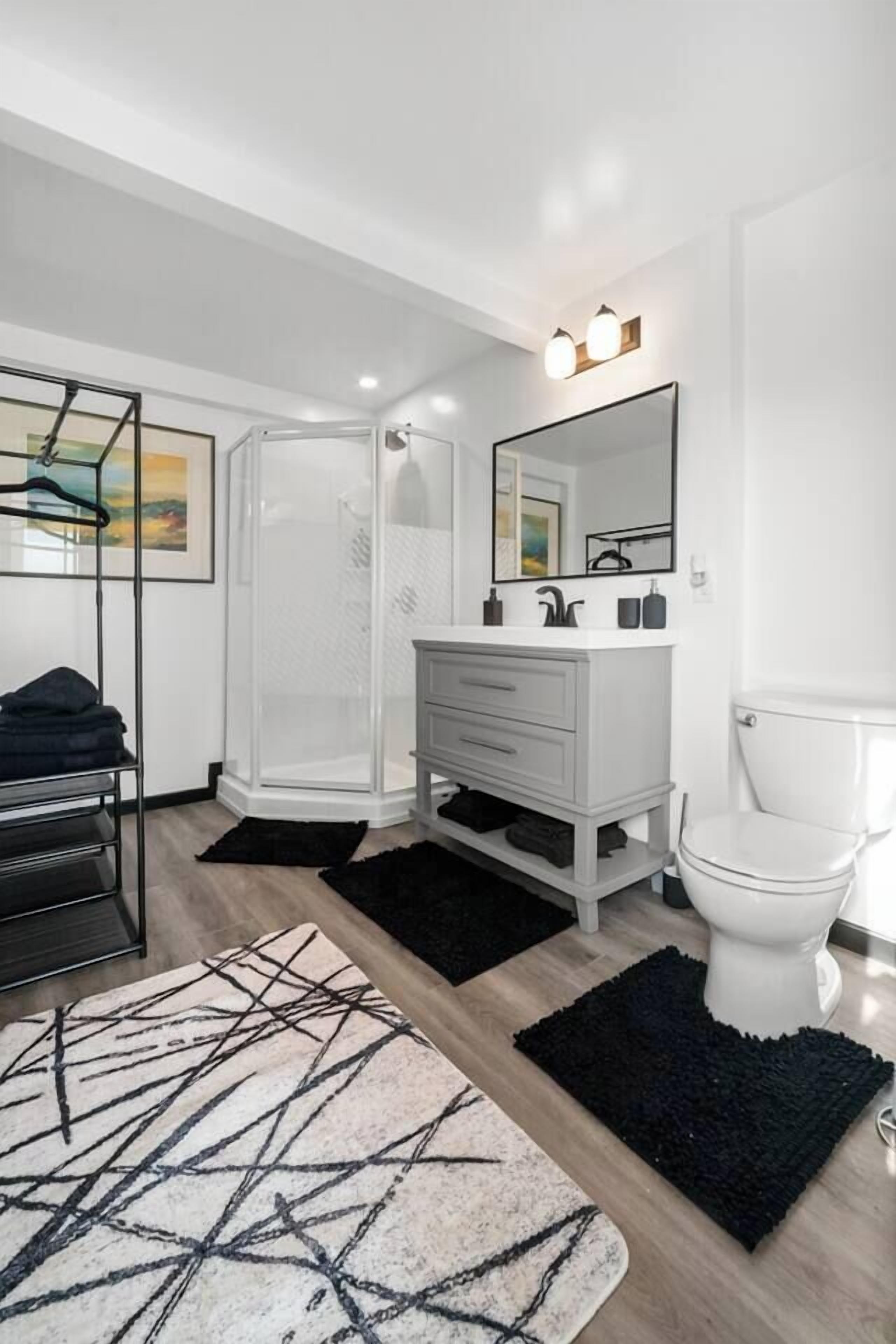 A modern bathroom with a shower, toilet, and vanity.