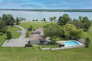 Ein Wohnhaus mit Pool, Garage und Rasenfläche.