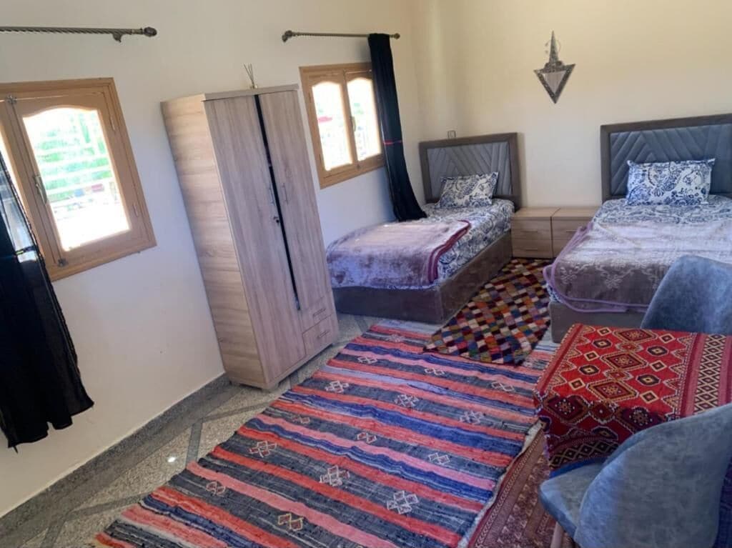 Una habitación con dos camas, un armario y una ventana.