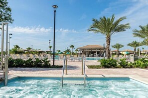 A pool area with lounge chairs and a palm tree. - 8BR Pool/Spa, Themed Movie,Games and Kids Rooms. Disney area Waterpark Resort (Davenport)