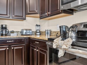 A modern kitchen with dark wood cabinets, stainless steel appliances, and granite countertops. - 8BR Pool/Spa, Themed Movie,Games and Kids Rooms. Disney area Waterpark Resort (Davenport)