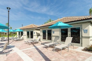 A poolside area with lounge chairs and umbrellas, a tiled patio, and a building with a sign indicating room number 11B. - 8BR Pool/Spa, Themed Movie,Games and Kids Rooms. Disney area Waterpark Resort (Davenport)