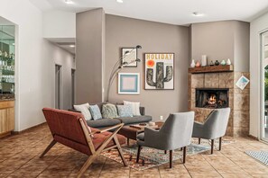 A living room with a fireplace, a coffee table, and a sofa. - Limonata Palm Springs (Palm Springs)