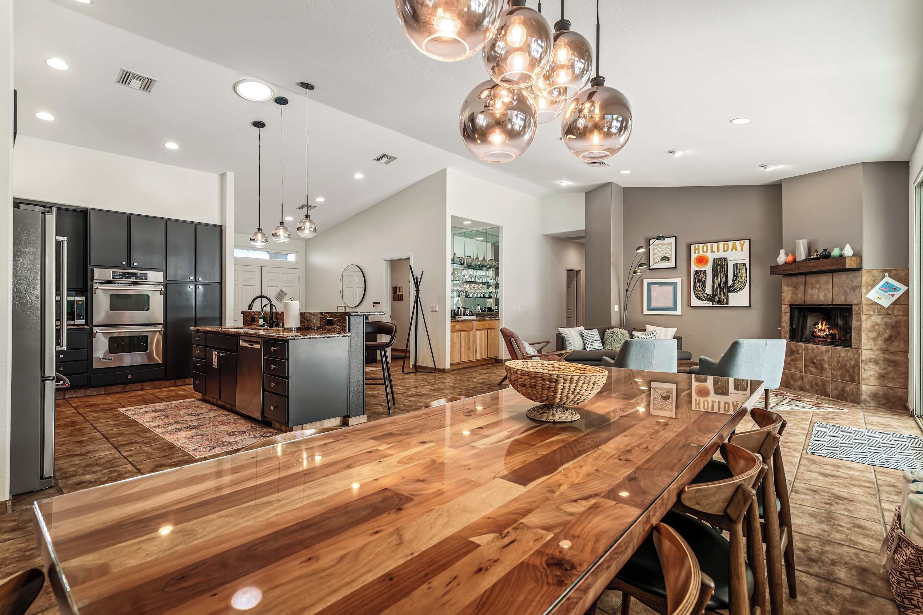 A modern kitchen with dark cabinets, a central island, and pendant lighting.