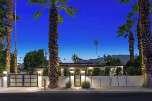 A modern building with a flat roof, surrounded by palm trees and a clear sky. - Casa Palmera-Mid Century Modern (Palm Springs)
