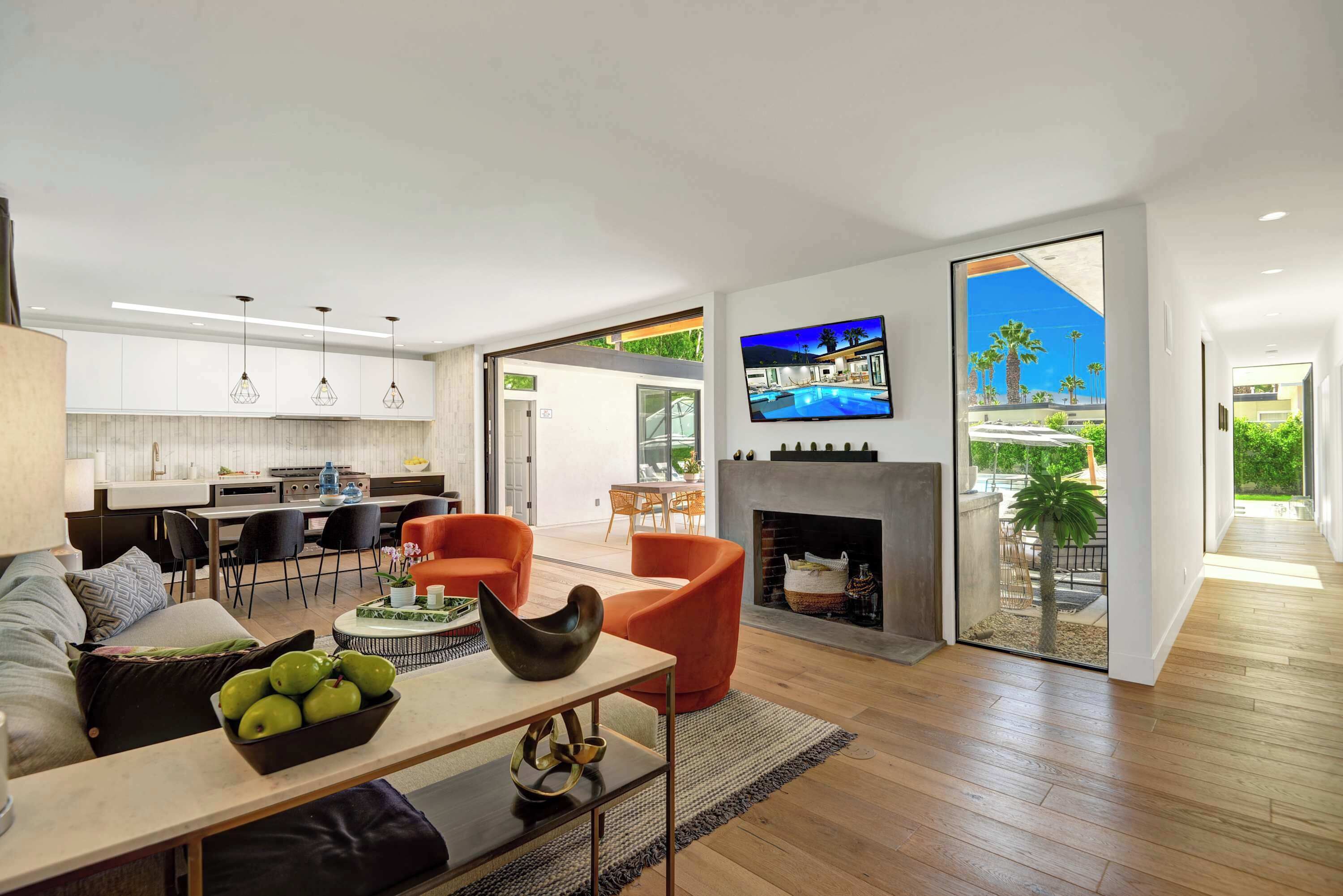 Una sala de estar moderna con chimenea, comedor y cocina.