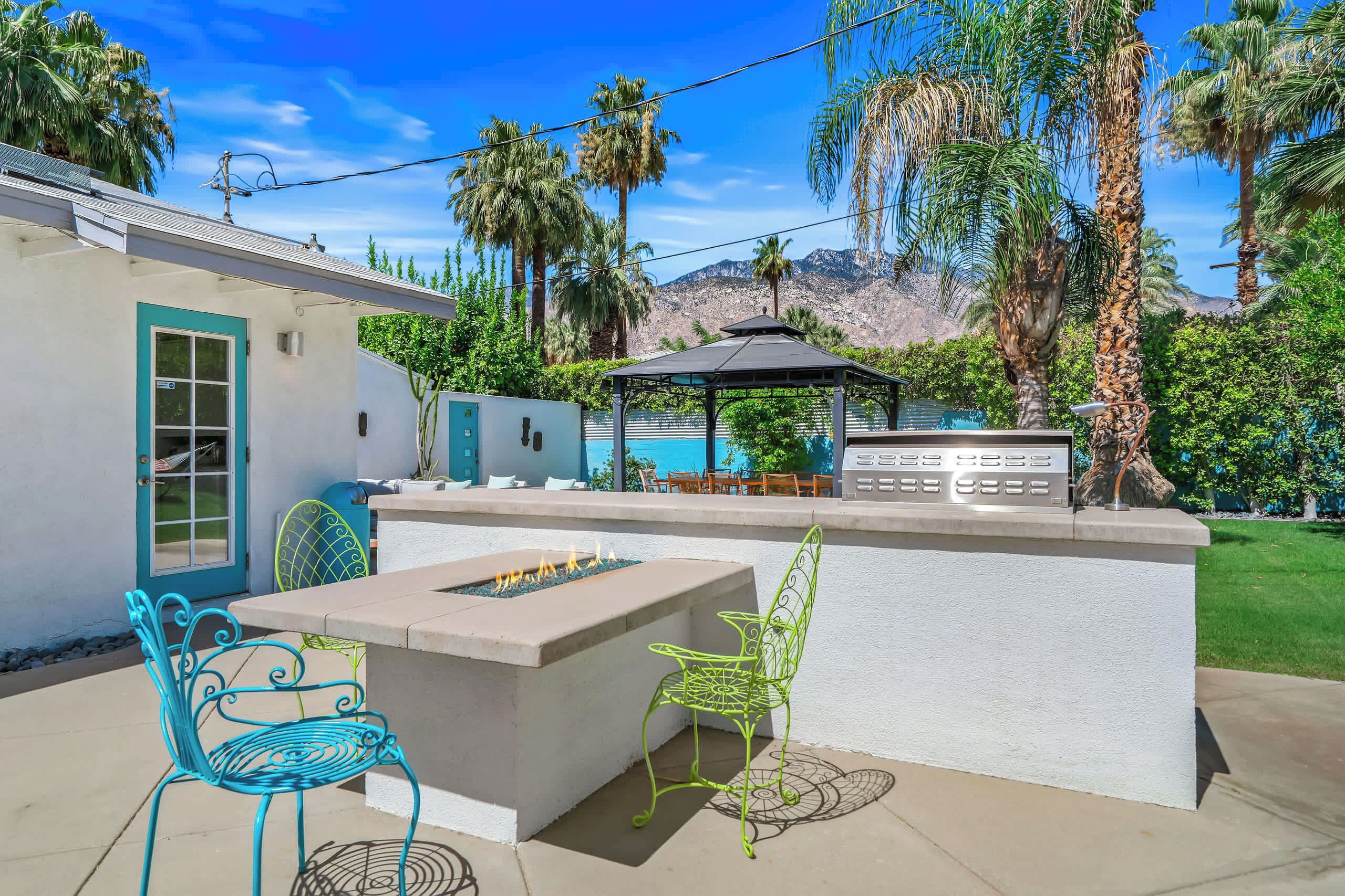An outdoor patio with a fire pit, seating, and a pool area.