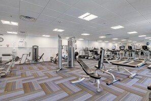 A gym with various exercise equipment, including treadmills, stationary bikes, and weight machines. - Furnished cozy 2-bedroom/2-bathroom condo 
in the resort-style gated community. (Boynton Beach)