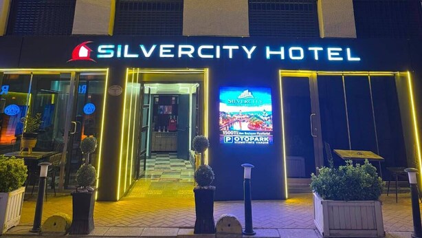 The exterior of the Silvercity Hotel with illuminated neon lines and a large digital display.