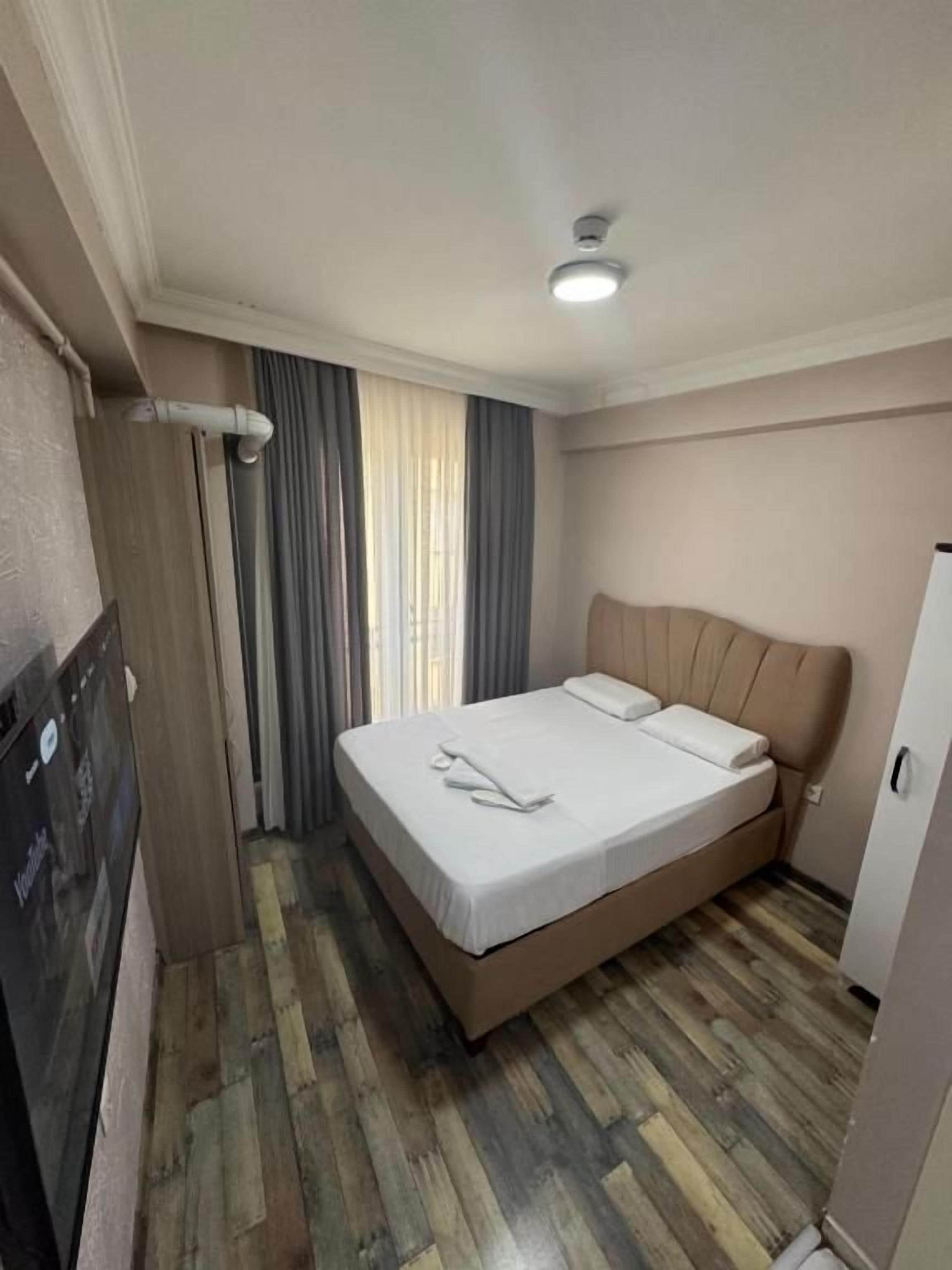 A hotel room with a bed, a television, and a wardrobe.