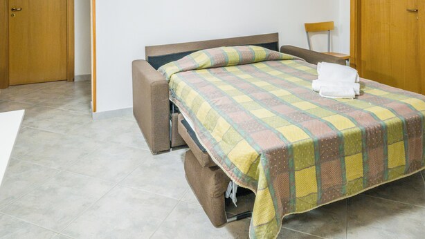 A single bed with a quilt, a wooden bench, and a door. - EmyHouse54 - Villetta con piscina (Martina Franca)