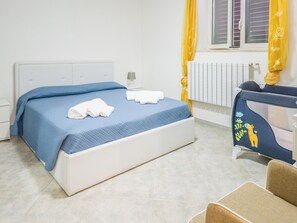 A bedroom with a bed, a nightstand, a chair, and a window with curtains. - EmyHouse54 - Villetta con piscina (Martina Franca)