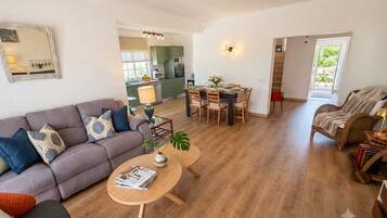 Een moderne woonkamer met een bank, salontafel en een eethoek.