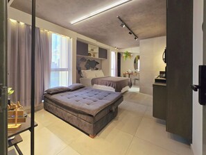 Ein modernes Schlafzimmer mit einem großen Bett, einem Schreibtisch und einer Sitzecke.