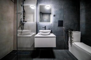 Ein modernes Badezimmer mit zwei Waschbecken, einer Toilette und einer Dusche.
