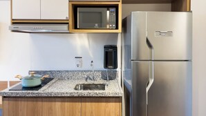 Una cocina moderna con un refrigerador de acero inoxidable, un microondas y un dispensador de agua.