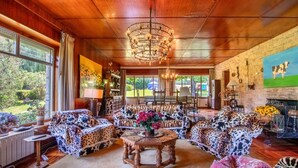 A spacious living room with a large wooden ceiling, a chandelier, and a view of the outdoors. - Villa with Large Garden and Pool (La Cavada)