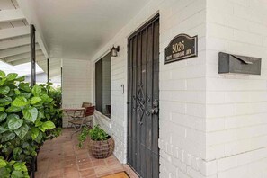 Una casa con puerta principal negra, buzón y un letrero que dice '5026 East Windsor Ave'.