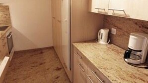 A compact kitchen with a refrigerator, a coffee maker, and a microwave. - Cristal Appartement/Fewo 4-Bettwohnung Nr. 5 by Interhome (Saas-Fee)