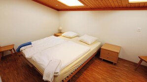 A bedroom with a wooden bed, two bedside tables, a nightstand, and a skylight. - Cristal Appartement/Fewo 6-Bettwohnung Nr. 25 by Interhome (Saas-Fee)