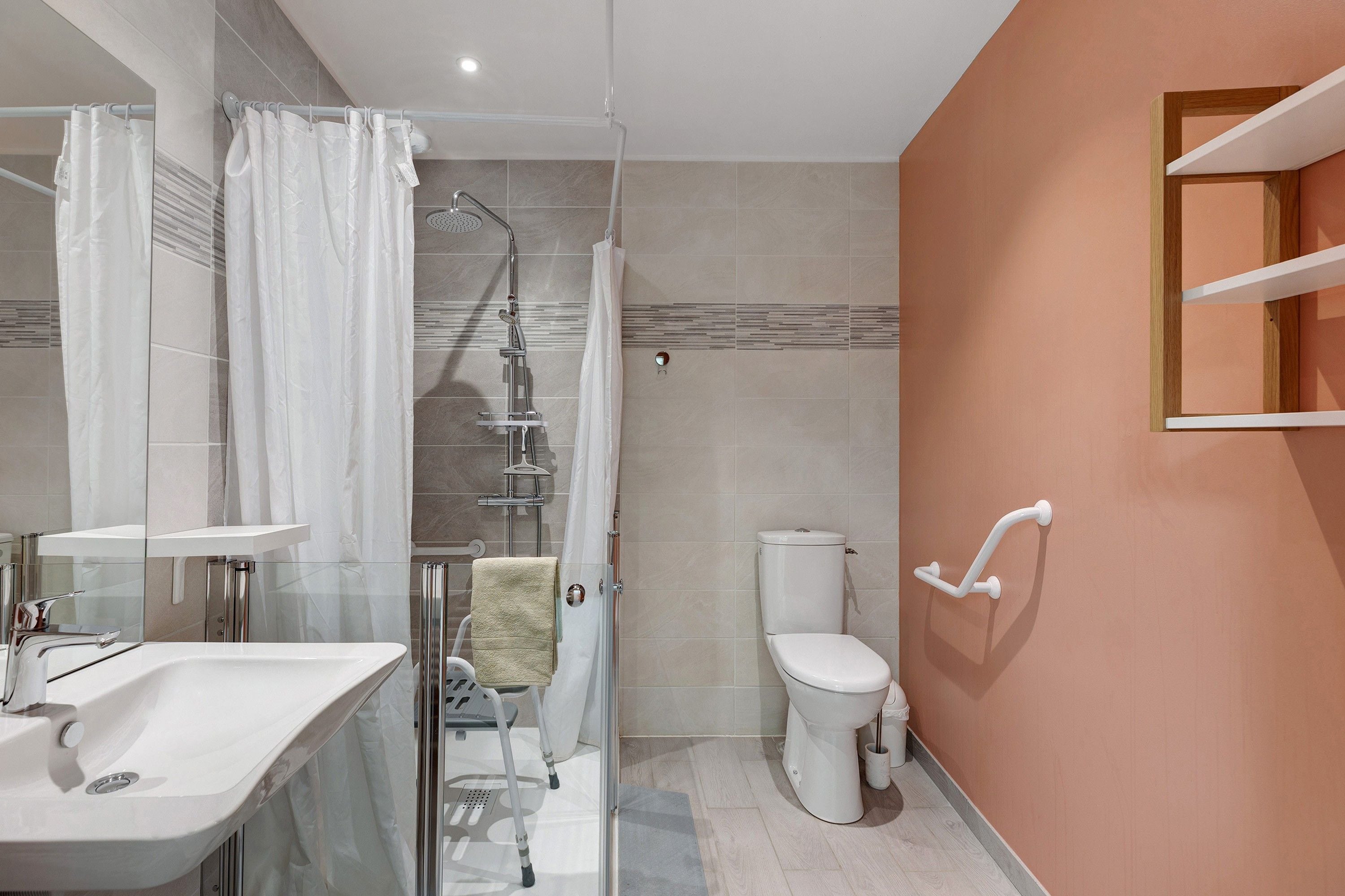 A modern bathroom with a glass shower enclosure, a white toilet, and a sink with a chrome faucet.