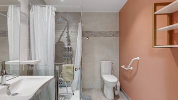 A modern bathroom with a glass shower enclosure, a white toilet, and a sink with a chrome faucet.