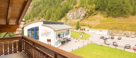 Ein Hotel mit Balkon und Blick auf einen Parkplatz sowie eine Berglandschaft.