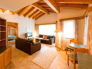 Ein gemütliches Wohnzimmer mit einer Couch, einem Couchtisch und einem Essbereich mit Tisch und Stühlen.